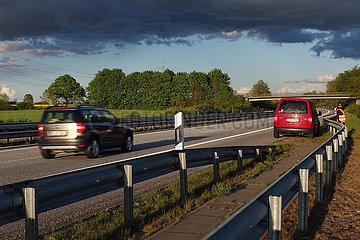 Hamburg  Deutschland  Frau steht bei einer Autopanne auf der A24 hinter der Leitplanke
