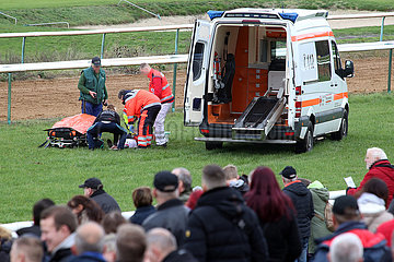 Magdeburg  Deutschland  Menschen schauen bei der Erstversorgung eines gestuerzten Reiters durch Rettungssanitaeter auf einer Galopprennbahn zu