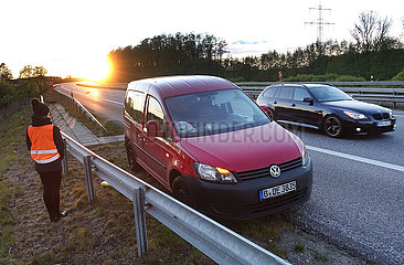 Hamburg  Deutschland  Frau steht bei einer Autopanne auf der A24 hinter der Leitplanke