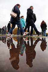 Magdeburg  Deutschland  Menschen spiegeln sich in einer Pfuetze