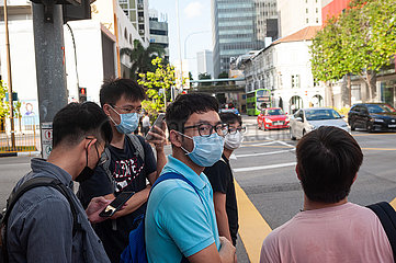 Singapur  Republik Singapur  Maenner mit Mundschutz im Stadtteil Chinatown