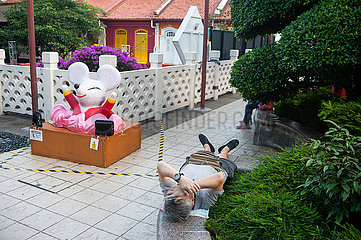 Singapur  Republik Singapur  Mann schlaeft in einem kleinen Park in Chinatown