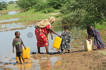 Burferedo  Somali Region  Aethiopien - Mutter und Kinder tragen Wasserkanister zu einer Wasserstelle