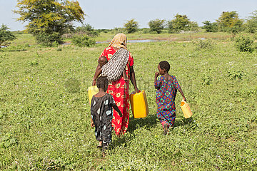 Burferedo  Somali Region  Aethiopien - Mutter und Kinder tragen Wasserkanister zu einer Wasserstelle