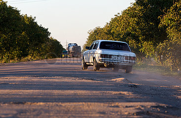 Republik Moldau  Vulcanesti - PKW schleicht am Strassenrand einer maroden Landstrasse im Sueden