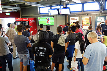 Schoenefeld  Deutschland  Menschen schauen in einer Wartehalle des Flughafen Schoenefeld ein Fussballspiel
