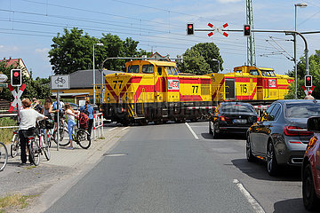 Luebben  Deutschland  Autos und Fahrradfahrer warten an einem Bahnuebergang auf die Durchfahrt eines Zuges