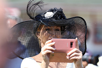 Hamburg  Deutschland  elegant gekleidete Frau mit Hut macht ein Foto mit ihrem Mobiltelefon