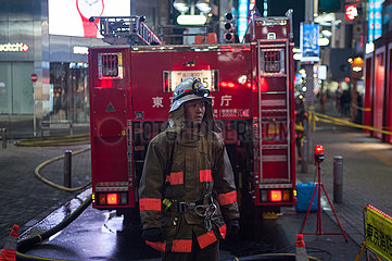 Tokio  Japan  Feuerwehrmann im Einsatz neben einem Loeschfahrzeug