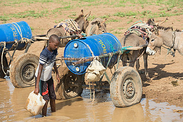 Burferedo  Somali Region  Aethiopien - Junge schoepft Wasser aus einer Wasserstelle