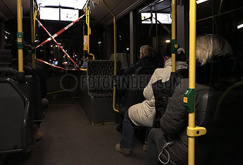 Berlin  Deutschland  Menschen sitzen am Morgen in einem Bus der BVG mit Absperrung zum Fahrerraum wegen der Coronapandemie