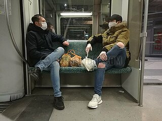 Zwei Maenner mit Atemschutzmaske in Berliner S-Bahn