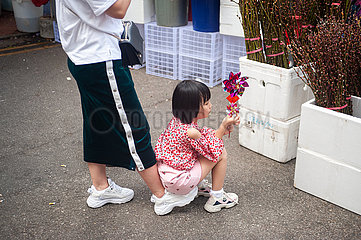 Singapur  Republik Singapur  Ein Maedchen sitzt auf dem Fuss seiner Mutter