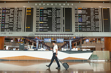 Singapur  Republik Singapur  Pilot vor Anzeigetafel mit Fluginformationen am Flughafen Changi