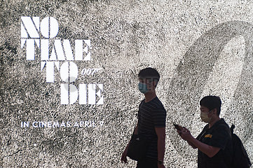 Singapur  Republik Singapur  Personen mit Mundschutz vor einer Werbung fuer James Bond Film
