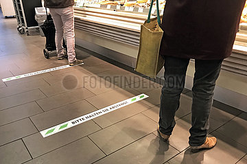 Berlin  Deutschland  Auswirkungen des Coronavirus: Bitte in einem Supermarkt auf das Einhalten des Sicherheitsabstandes von 1 5 Meter zwischen den Kunden