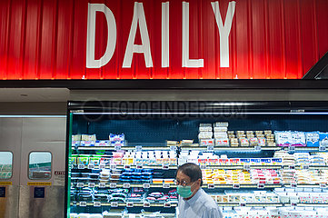 Singapur  Republik Singapur  Mann mit Mundschutz kauft in einem Supermarkt ein