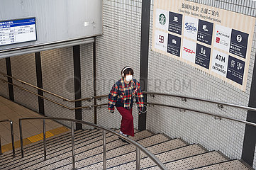 Kyoto  Japan  Frau mit Mundschutz geht Treppe einer U-Bahnstation hoch