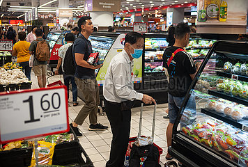 Singapur  Republik Singapur  Aelterer Mann mit Mundschutz kauft in einem Supermarkt ein