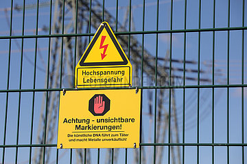 Nunsdorf  Deutschland  Hinweisschilder - Kuenstliche DNA - und - Hochspannung Lebensgefahr - am Zaun eines Umspannwerks