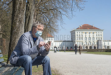 aelterer Mann mit Munschutz  Nymphenburger Schlosspark  Muenchen  April 2020