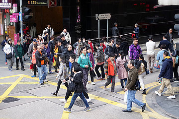 Hongkong  China  Menschen uberqueren eine Strasse