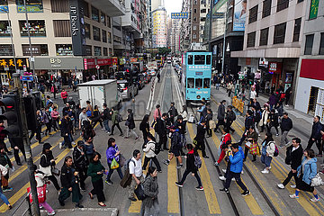 Hongkong  China  Menschen ueberqueren eine Strasse