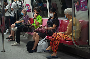 Singapur  Republik Singapur  Fahrgaeste mit Mundschutz in einer U-Bahn