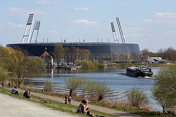 Deutschland  Bremen - Menschen geniessen die Sonne am Osterdeich an der Weser  hinten das Weserstadion vom SV Werder Bremen