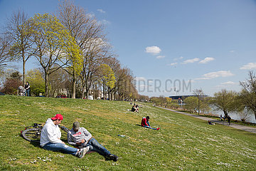 Deutschland  Bremen - Menschen geniessen die Sonne am Osterdeich an der Weser  hinten das Weserstadion