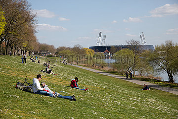 Deutschland  Bremen - Menschen geniessen die Sonne am Osterdeich an der Weser  hinten das Weserstadion