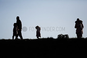 Deutschland  Bremerhaven - Familie auf Spaziergang auf dem Deich an der Muendung der Weser zur Nordsee