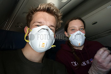 Minneapolis  USA  Teenager sitzen in Zeiten der Coronapandemie mit Atemschutzmasken in einem Flugzeug