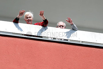 Berlin  Deutschland  Senioren stehen winkend auf ihrem Balkon