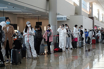 Atlanta  USA  Auswirkungen der Coronapandemie: Flugpassagiere stehen im Schutzanzug und Atemmasken im Terminal des Flughafen in einer Warteschlange