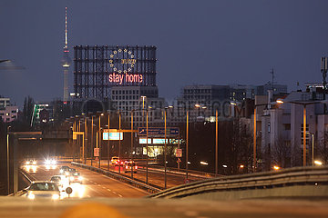 Berlin  Deutschland  Blick auf den Gasometer Schoeneberg mit dem Schriftzug stay home und den Berliner Fernsehturm bei Daemmerung