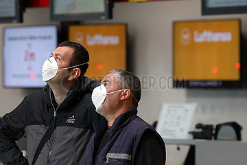 Berlin  Deutschland  Auswirkungen der Coronapandemie: Maenner mit Mund-Nasen-Schutz im Terminal des Flughafen Tegel