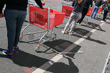Deutschland  Bremen - Warteschlange wegen Corona: Kunden mit Einkaufswagen vor einem Baumarkt