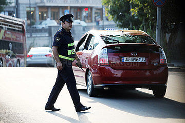 Batumi  Georgien  Polizist ueberquert eine Strasse