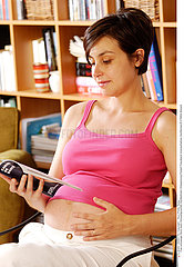 FEMME ENCEINTE INTERIEUR LECTURE PREGNANT WOMAN INOORS READING