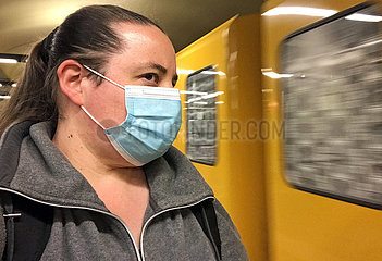 Berlin  Deutschland  Frau auf einem U-Bahnhof traegt in Zeiten der Coronapandemie einen Mund-Nasen-Schutz