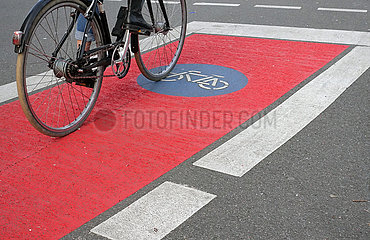 Mannheim  Deutschland  Radfahrer faehrt auf einem rot gekennzeichneten Fahrradweg