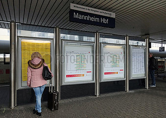 Mannheim  Deutschland  Frau informiert sich ueber die Zugabfahrten auf einem Bahnsteig im Hauptbahnhof
