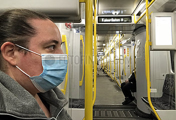 Berlin  Deutschland  Frau in einer U-Bahn traegt in Zeiten der Coronapandemie einen Mund-Nasen-Schutz