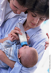 INFANT DRINKING FROM BABY BOTTLE