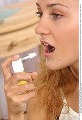 WOMAN USING SPRAY IN MOUTH