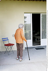 ELDERLY PERSON OUTDOORS W. CANE