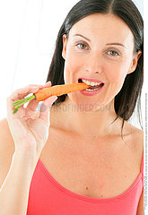 WOMAN EATING RAW VEGETABLES