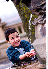 CHILD PLAYING W. WATER OUTDOORS