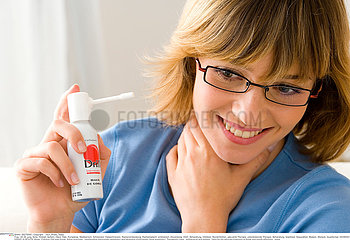 WOMAN USING SPRAY IN MOUTH